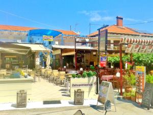 a group of buildings with tables and chairs at Studios Elina in Skala Potamias