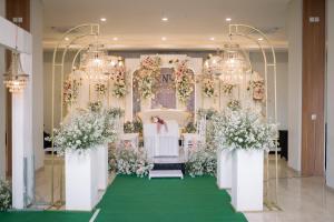 een huwelijksaltaar met bloemen en een bruid bij Front One Hotel Gombong in Gombong