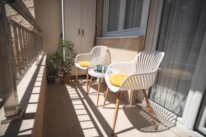 three chairs and a table on a balcony at Sea Colours Apartment Budva in Budva
