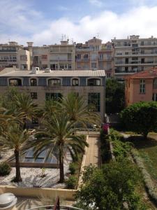 un edificio con palmeras frente a una ciudad en Floreva, en Niza