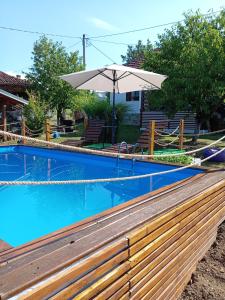 una piscina con una valla de madera y una sombrilla en ZOĆEVIĆA KONAK, en Petrovići