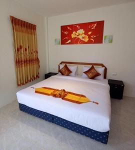 a bedroom with a large white bed with yellow blankets at At night Airport Resort in Patong Beach