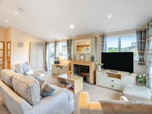 Una sala de estar con sofás y un televisor de pantalla plana. en Seagull Lodge - Uk48631, en Runswick