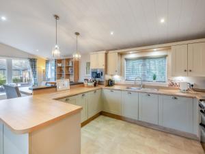 Una cocina con gabinetes blancos y una ventana grande. en Seagull Lodge - Uk48631, en Runswick