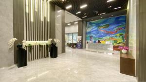a lobby with a large painting on the wall at REOTEL at CITRAPLAZA NAGOYA BATAM in Jodoh