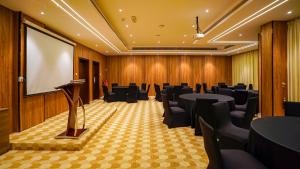 杜科姆Duqm Express Hotel的配有桌椅和屏幕的会议室