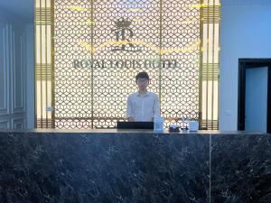 a man sitting at a counter with a laptop at Royal Louis Hotel in Hanoi
