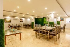 a dining room with tables and chairs and green walls at Treebo Red Coral in Haridwār