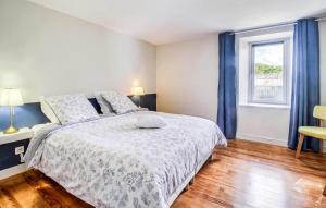 Un dormitorio con una cama grande y una ventana en Ravissante Maison Bretonne, en Pleumeur-Gautier