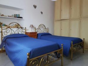 1 dormitorio con 2 camas con sábanas azules y vestidor en Casa Stefania, en Lorano