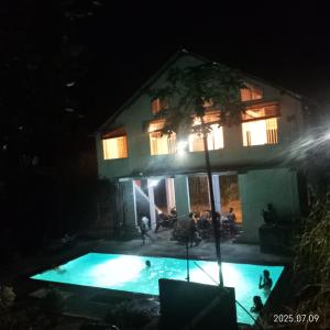 a house with a swimming pool at night at Kit Cott Resort and Retreat in Teligama
