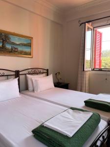 two twin beds in a bedroom with a window at Hotel Esperides in Kardamyli