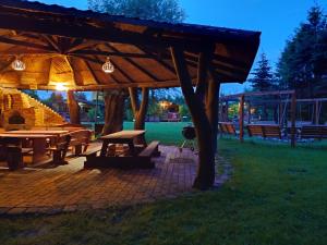 a picnic area with tables and a pavilion at night at Koło Żółwia in Gąski