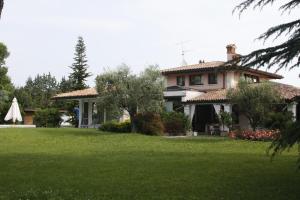 ein Haus mit grünem Rasen davor in der Unterkunft Le Margherite in Manerba del Garda