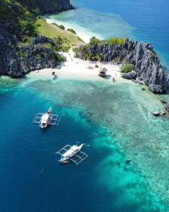 twee boten in het water naast een strand bij Anang Balay Turista in El Nido +20 foto's
