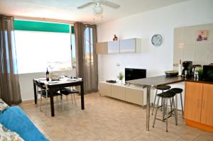 Il comprend une cuisine et un salon avec une table et des chaises. dans l'établissement Apartment With Great Seaview, à Puerto de Santiago