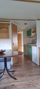 an empty room with a table and a kitchen at Leśna Aura in Ponizie +38 photos