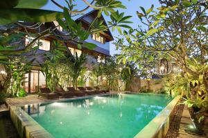 a pool in the middle of a house with trees at Puri Sabina Bed & Breakfast in Jimbaran