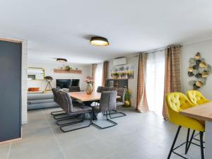 a living room with a dining room table and yellow chairs at RE with pool and spa Comfortable holiday residence in Slivnica