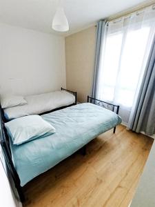 a bedroom with two beds and a window at Appartement 3 chambres à Sedan in Sedan +3 photos