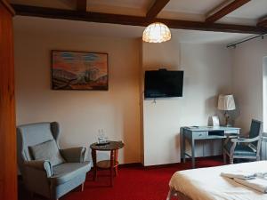 a hotel room with a bed and a desk and a tv at Hotel Restauracja Jaś Wędrowniczek in Rymanów
