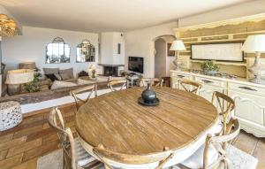 a kitchen and living room with a wooden table and chairs at Awesome Home In Les Adrets D L'estérel in St Jean de l’Esterel