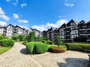 a row of apartment buildings with bushes and trees at Aspen Resort Studio I306 in Razlog
