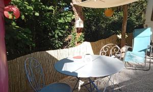 a white table and chairs on a patio at La Vintage insolite in Lacaze +8 photos