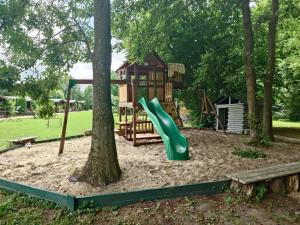 a playground with a slide and a tree at Koło Żółwia in Gąski