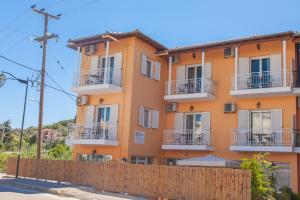 a building with balconies and a fence at Melissi in Lefkada Town