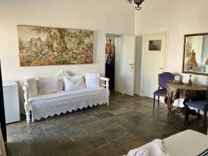 a living room with a white couch and a painting at Fanivevisgarden in Chora Folegandros