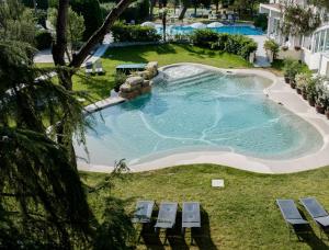 an overhead view of a swimming pool with chaise lounge chairs at Hotel Terme Milano in Abano Terme