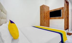 Un dormitorio con una cama blanca con una almohada amarilla. en Hotels Heraa International, en Bombay