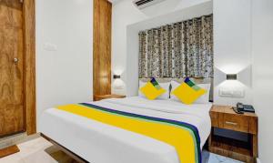 1 dormitorio con 1 cama blanca grande con almohadas amarillas y azules en Hotels Heraa International, en Bombay