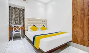 a bedroom with a bed and a chair in it at Hotels Heraa International in Mumbai