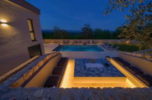 a villa with a swimming pool at night at Villa ASTRUM with heated indoor and outdoor pool, jacuzzi and sauna in Vrh
