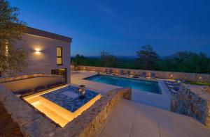 a swimming pool in the backyard of a house at Villa ASTRUM with heated indoor and outdoor pool, jacuzzi and sauna in Vrh +49 photos