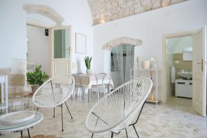 a dining room with white chairs and a table at A L Tourist House - La Corte Bianca - La Torre Blu in Carovigno