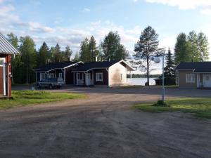 un gruppo di case con un'auto parcheggiata nel vialetto di Ristijärven Pirtti Cottage Village a Ristijärvi