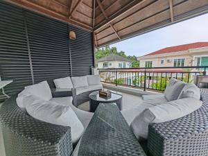 a covered patio with couches and a table with a table at Borneo Bali Villa by Meetstay in Sandakan