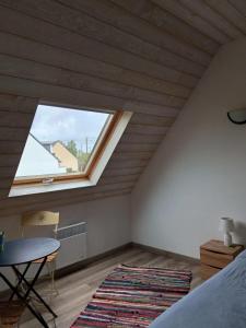 ein Schlafzimmer mit einem Fenster, einem Tisch und einem Bett in der Unterkunft Maison charmante avec jardin et barbecue à Penmarch in Penmarcʼh