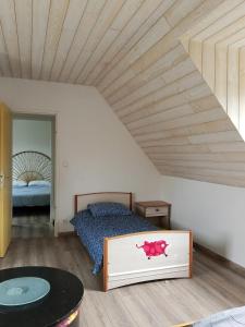 ein Schlafzimmer mit einem Bett und einer Holzdecke in der Unterkunft Maison charmante avec jardin et barbecue à Penmarch in Penmarcʼh + 17 Fotos