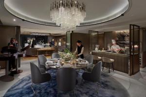 uma sala de jantar com uma mesa e uma cozinha em The Landmark Mandarin Oriental Hong Kong em Hong Kong mais 37 fotografias