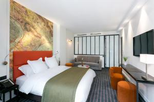 una camera d'albergo con un grande letto e un divano di Hotel Scarlett a Parigi