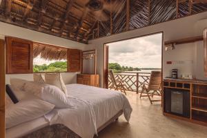 una camera da letto con un letto e un balcone con vista di Islawa Soy Local - Isla Privada a Barú