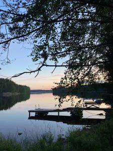 een dok op een meer met een boot in het water bij Metsäsydän mökki 3 Vinksinvonksin  +26 foto's