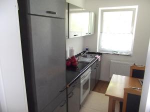 a kitchen with a stainless steel refrigerator and a sink at Fewo-Knaus in Holzminden