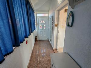 a hallway with blue drapes and a hallway with a door at Apartmani Ima in Ližnjan