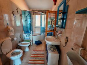 a bathroom with two toilets and a sink and a tub at Apartmani Ima in Ližnjan