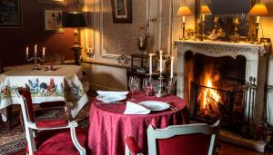 een eetkamer met een tafel en een open haard bij Château de l'Abbaye - Teritoria in Moreilles